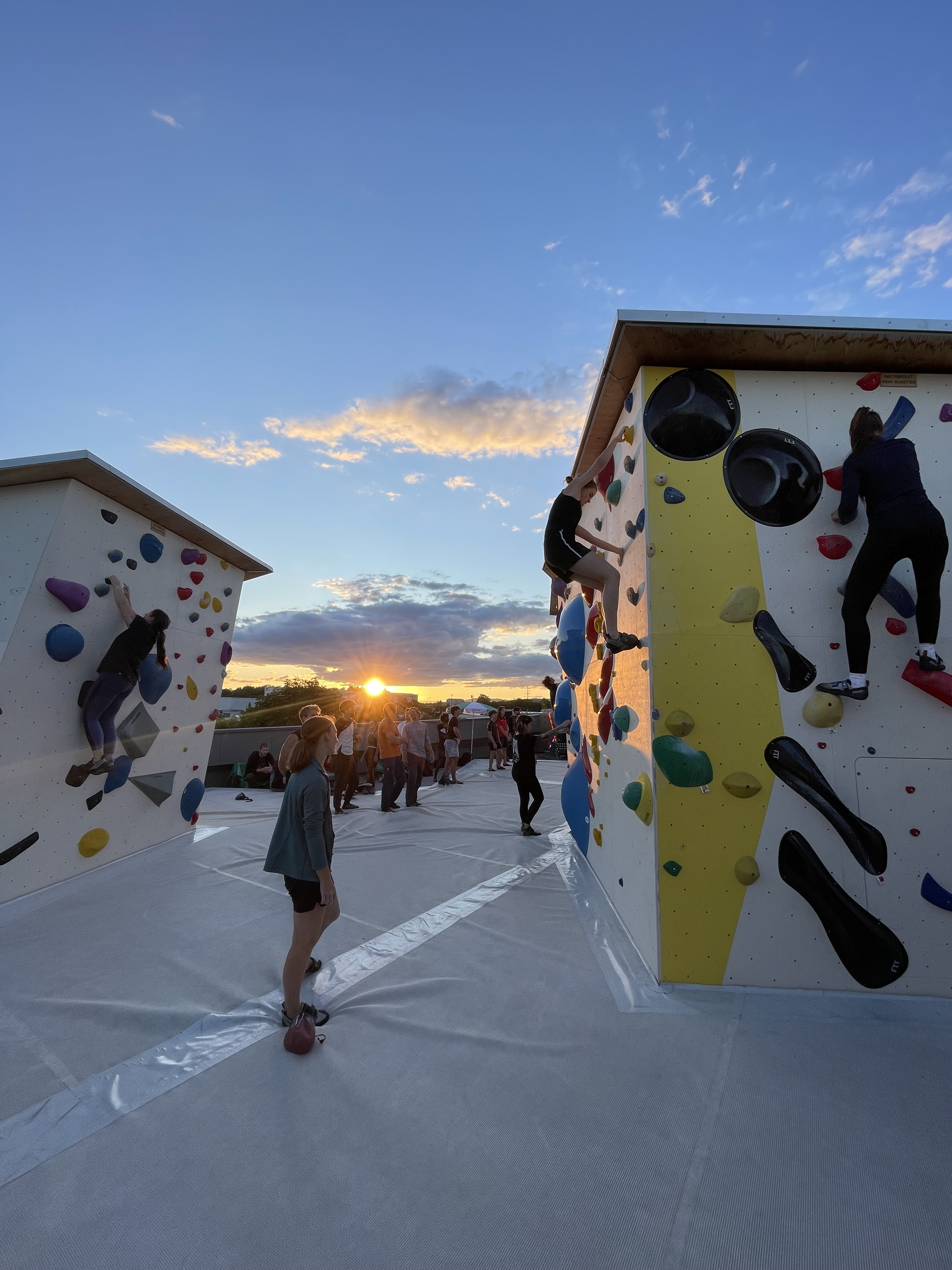 Viele Menschen bouldern auf dem Rooftop in Abendstimmung