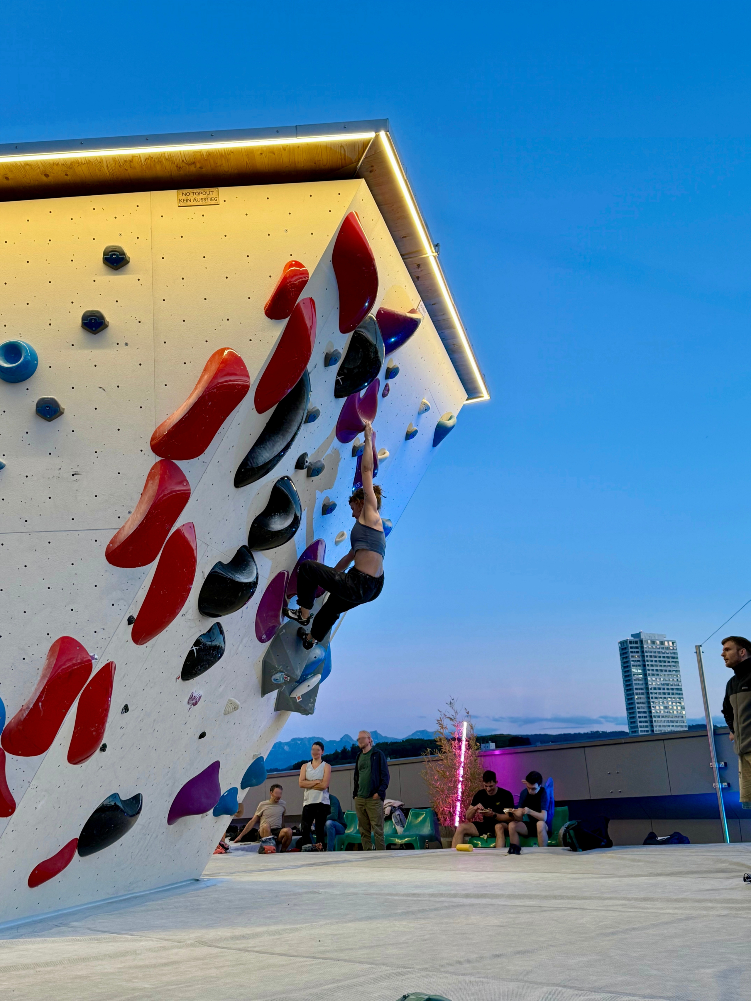 Viele Menschen bouldern auf dem Rooftop in Abendstimmung